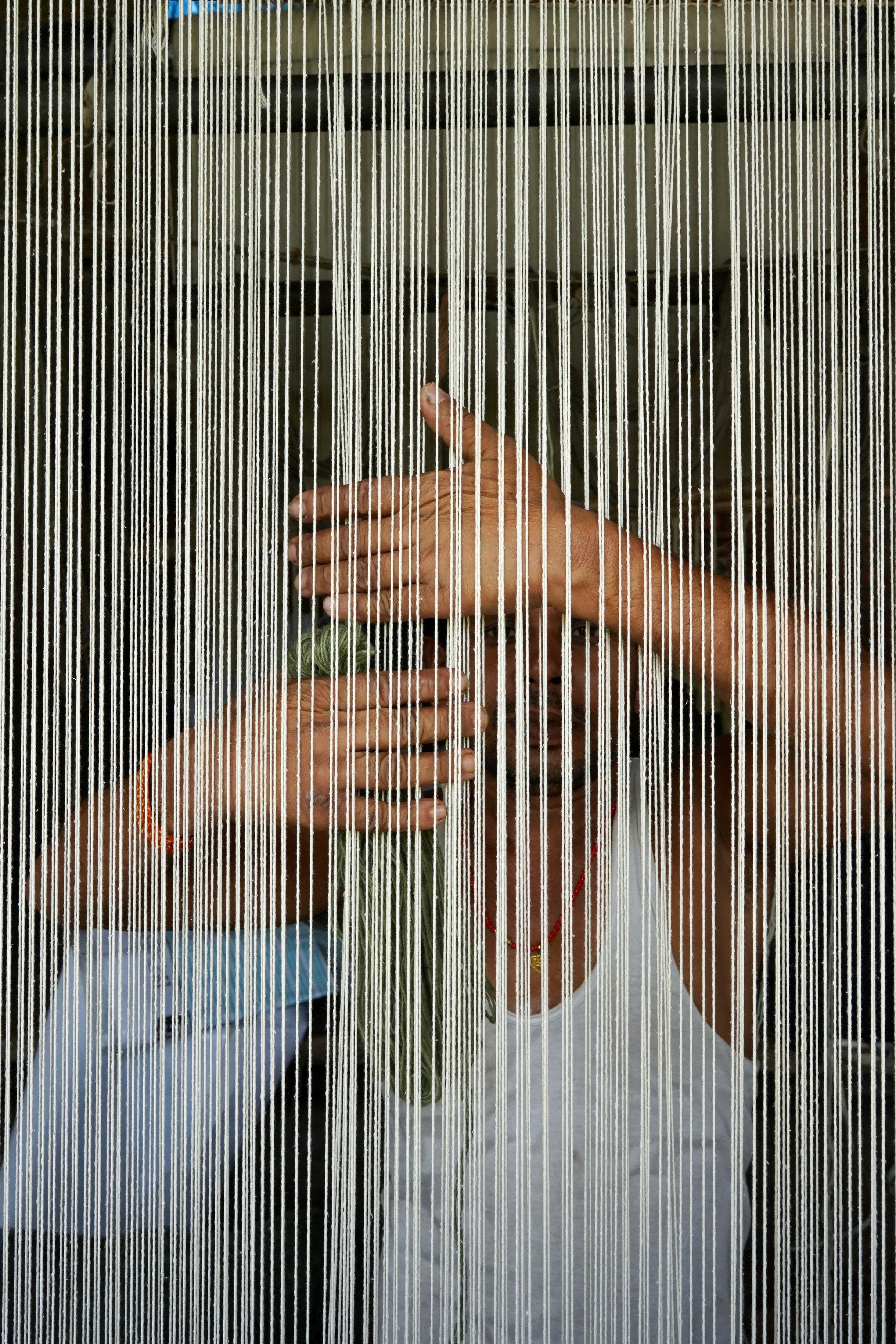 Artisan weaving a hand-knotted rug on a traditional loom in the House of Rugs Bhadohi workshop
